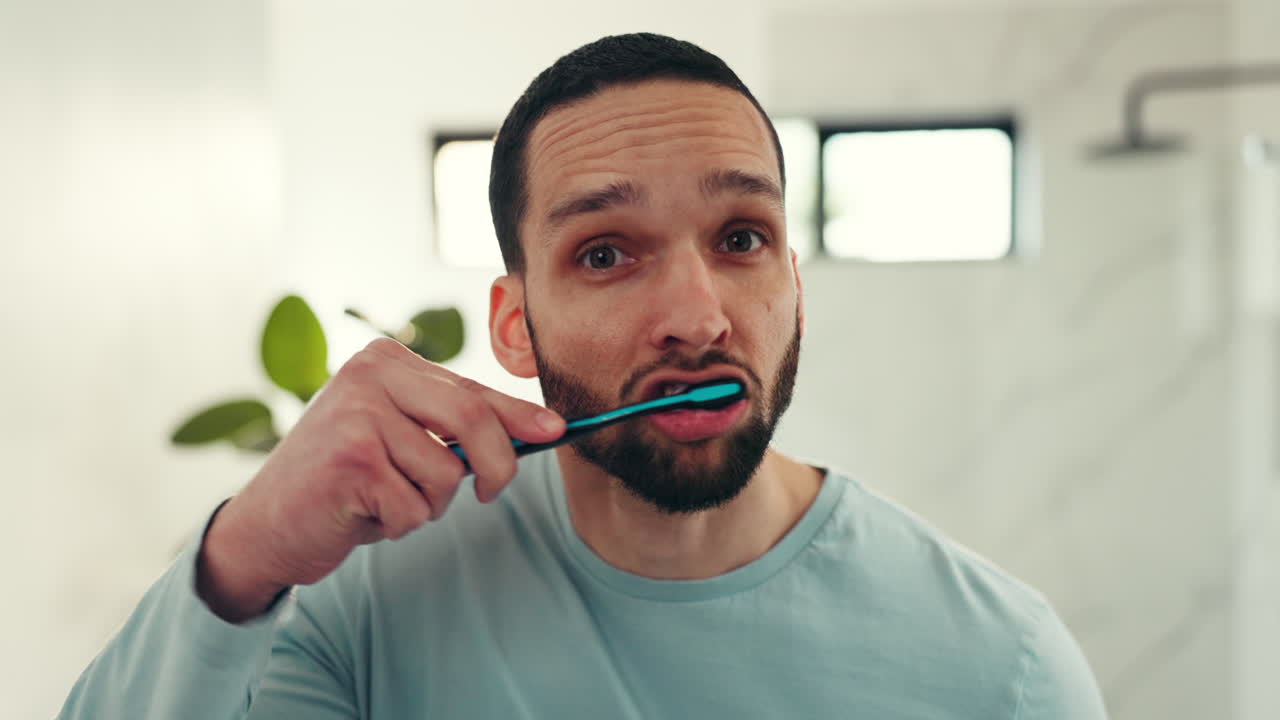 Man brushing teeth in bathroom