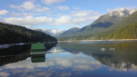 capilano lake reservoir, 2 lions mountain, base of grouse mountain north vancouver bc, aerial drone view flying up long shot, on a sunny day, north shore west vancouver british columbia