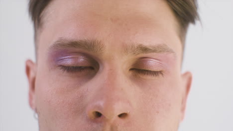 close up of blonde guy with blue eyes looking at front