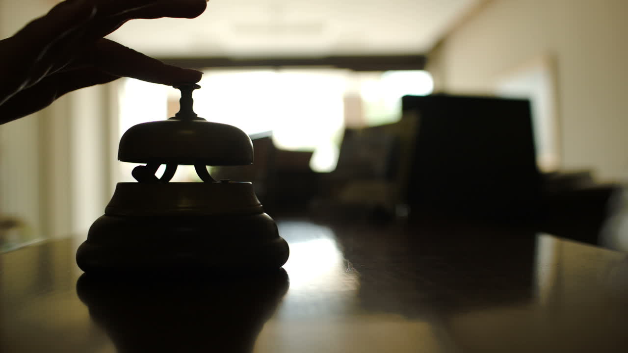 Wanita membunyikan bel di resepsionis hotel