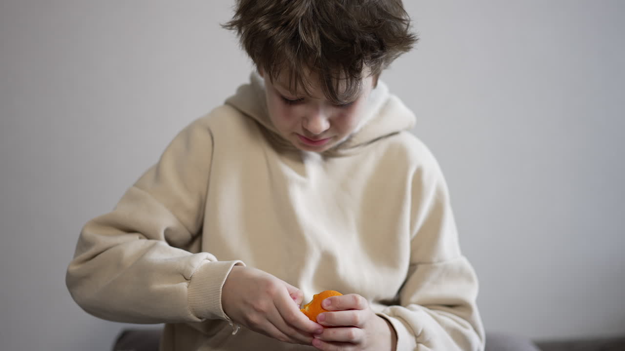 Gutt skreller en appelsin