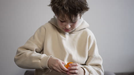 boy peeling an orange