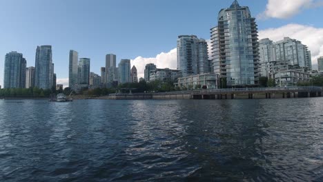 aerial low fly by just 1 feet above the water thru false creek bc vancouvers private yacht parking for the elite few at the most expensive housing building by the water pier passing parked boat