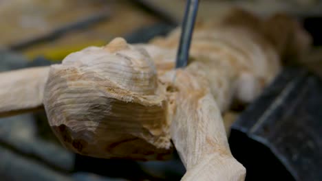 italian sculptor in his workshop working on a olive wood statue