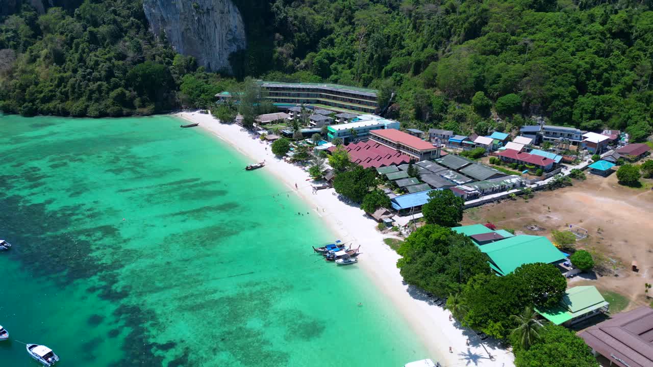 Aerial View of a Tropical Beach Resort with Turquoise Water and Lush Mountains