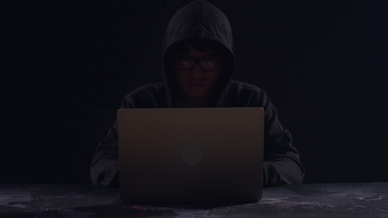 Asian Male Hacker Using Laptop Computer Hacking With Dark Background