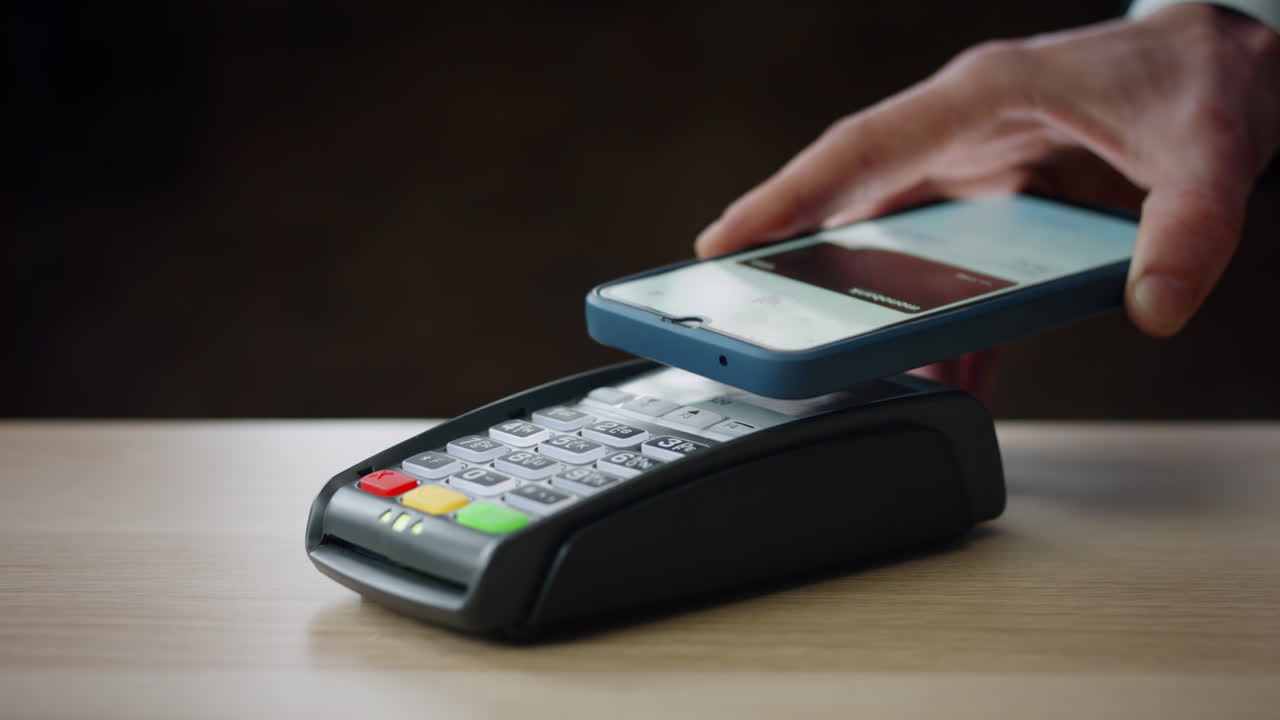 pago sin efectivo con teléfono inteligente en la terminal bancaria moderna en el interior de cerca.