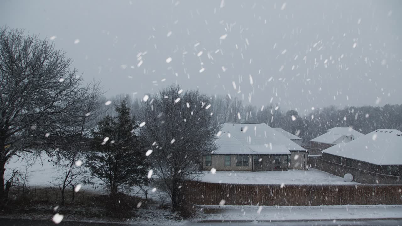 울타리로 도로와 분리된 배경의 이웃과 함께 빠르게 내리는 눈
