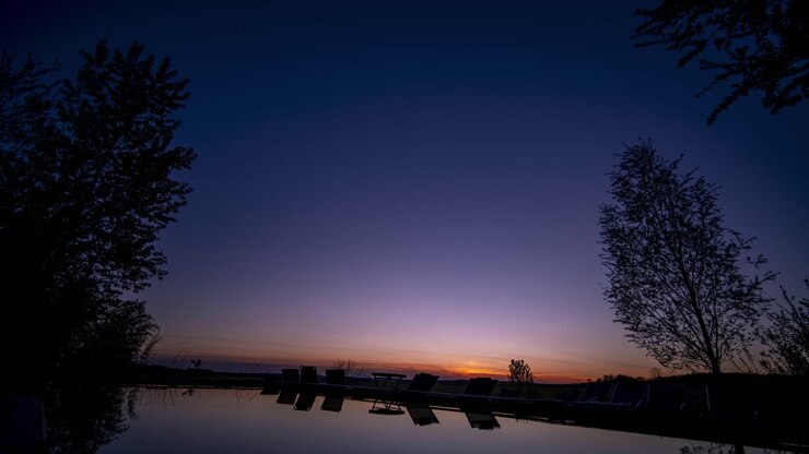 Silhouette in timelapse di persone a bordo piscina di notte in Alsazia, Francia