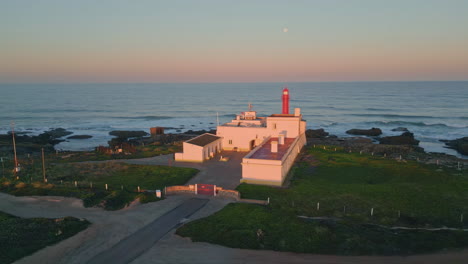 amazing evening coastal lighthouse aerial view. pink sky over beautiful ocean