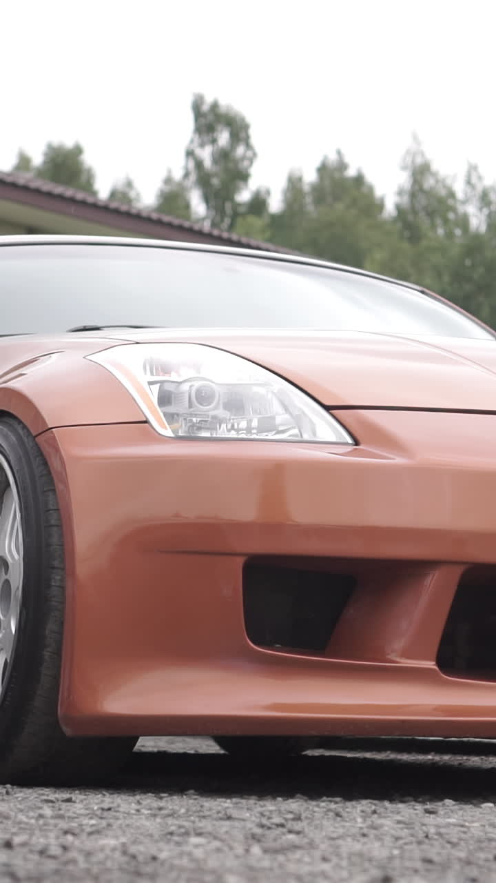Person walking near a modified orange sports car