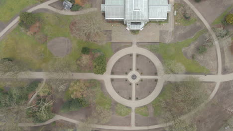 top down aerial of old indoor botanic garden in a small green park