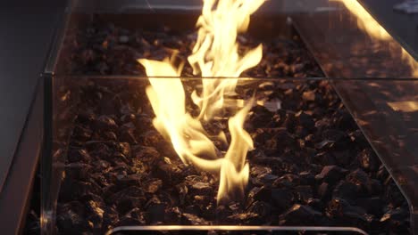 disparo en primer plano de un fuego de carbón negro que brilla incorporado a una mesa