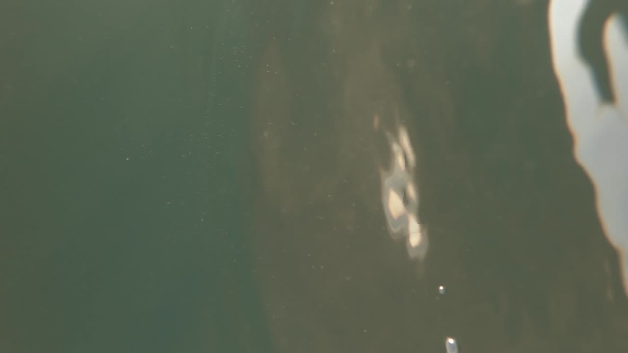 filmación cinematográfica submarina en la playa con imágenes divididas con la cámara medio sumergida en el agua | tiro vertical