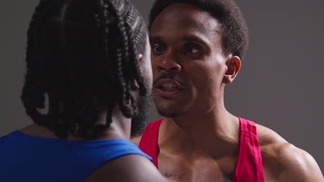 close up of two male boxers going head to head before boxing match staring into opponent's face and trash talking