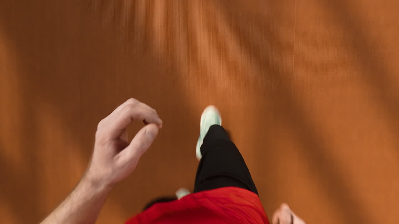 First Person View of Person Walking on a Brown Floor