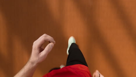 first person view of person walking on a brown floor