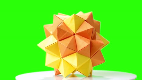 modular origami flower on green screen.