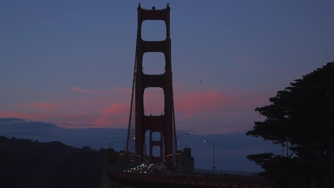 Luci delle auto nel traffico, tramonto arancione rosa rosso, Bay Area, Golden Gate Bridge, San Francisco California, Fort Point National Historic Site, punto panoramico, centro visitatori, Oceano Pacifico, inquadratura statica della città.
