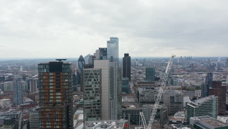 Vista-Panorámica-Aérea-Del-Grupo-De-Altos-Edificios-De-Oficinas-Modernos.-Torre-Principal-Y-Construcción-De-Un-Nuevo-Rascacielos-Al-Lado.-Londres,-Reino-Unido