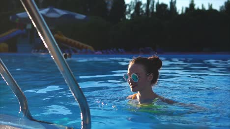 young woman in yellow bikini at swimming pool