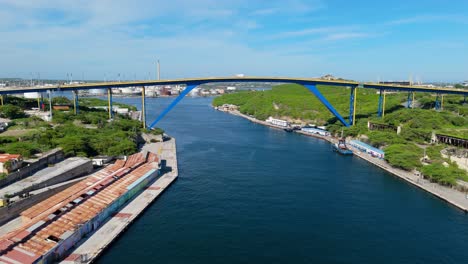 drone wide angle ascends to reveal oil refinery behind queen juliana bridge, willemstad curacao