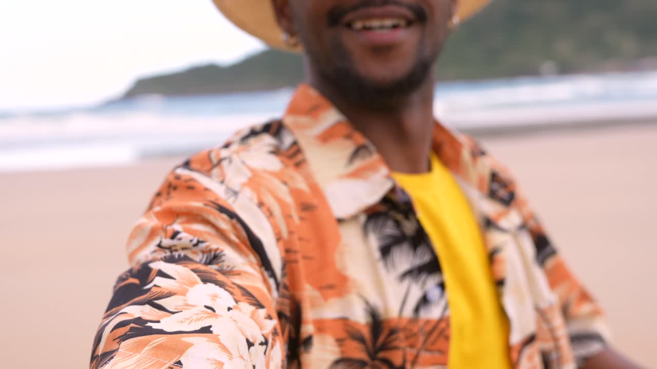 Man on the beach wearing sunglasses and a hat