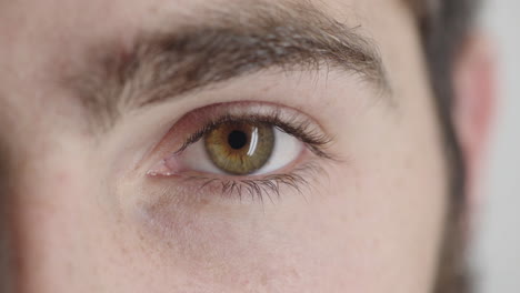 hombre de ojo verde mirando de cerca parpadeando pensativo contemplativo emoción óptica