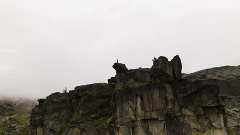 Person-Standing-On-Top-Of-The-Canon-Rock-Formation-In-Hellmojuvet,-Norway