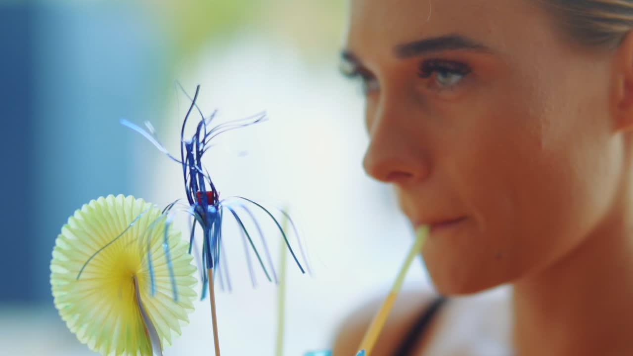 la ragazza sta bevendo un cocktail da una cannuccia