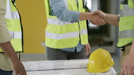 un grupo de constructores irreconocibles que se dan la mano