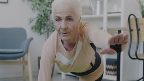 senior woman doing a plank exercise at home