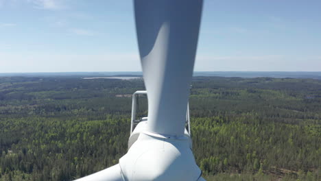 Drone-pullback-POV-close-to-spinning-blades-of-wind-turbine-in-Scandinavia