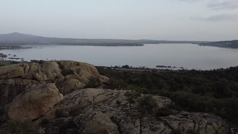 Vista-De-La-Carretera-Y-El-Lago-Detrás-De-Ella-Desde-La-Colina-Rocosa