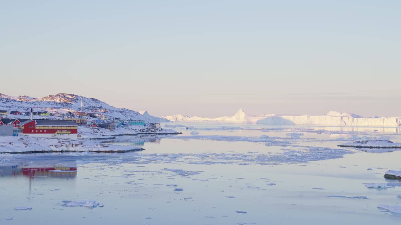 얼음과 바다를 가진 해안선에 있는 빛이 빛나는 도시 ilulissat icefjord