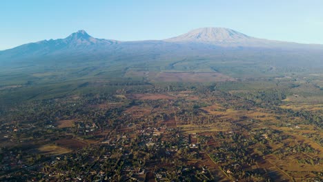 Sonnenaufgang-–-Kenia-Landschaft-Mit-Einem-Dorf,-Kilimandscharo-Und-Amboseli-Nationalpark-–-Verfolgung,-Drohnen-Luftaufnahme