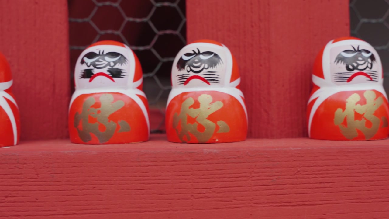 File di statuette Daruma rosse, arancioni e bianche esposte al Tempio Katsuoji rappresentano determinazione, perseveranza, vittoria e il perseguimento di obiettivi personali nella tradizione giapponese.