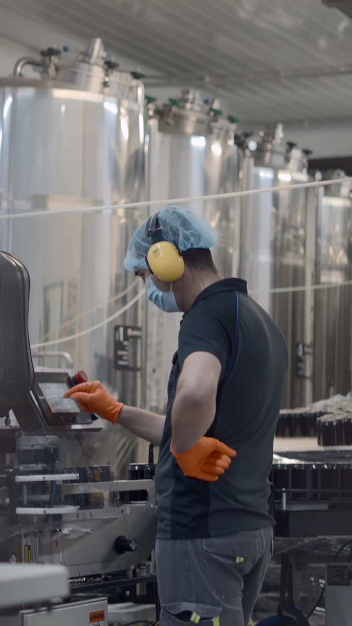 Worker operating machinery in a food or beverage processing plant