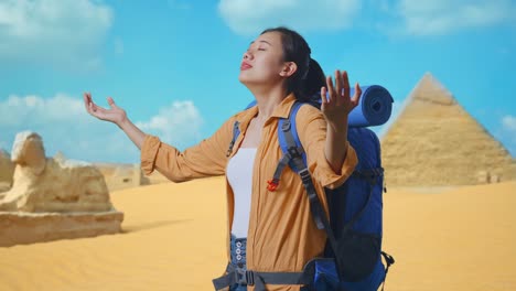 side view of asian female hiker with mountaineering backpack smiling and spreading arms enjoy looking the view around while traveling in pyramid of giza