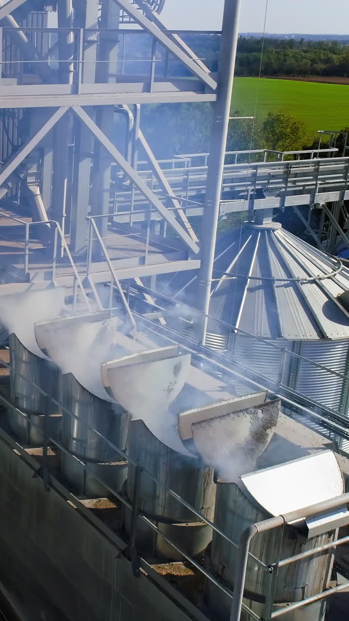 Metal elevator in agriculture zone. Grain Warehouse or depository. Vertical video