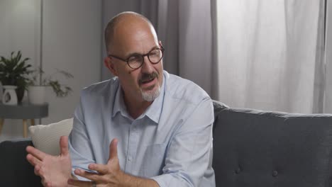 mature man sitting on sofa talking with female counsellor about general or mental health issue 20