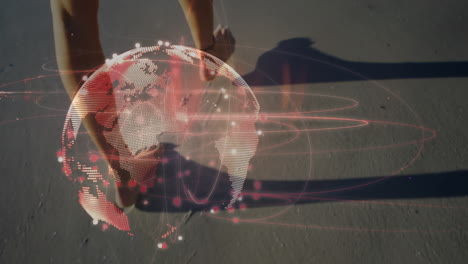 animation of glowing global network over legs of woman walking on sandy beach