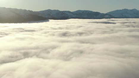 Drone-flying-above-mountain-clouds-during-sunset