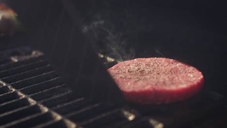 disparo a cámara lenta de las jugosas hamburguesas rojas colocadas en la parrilla