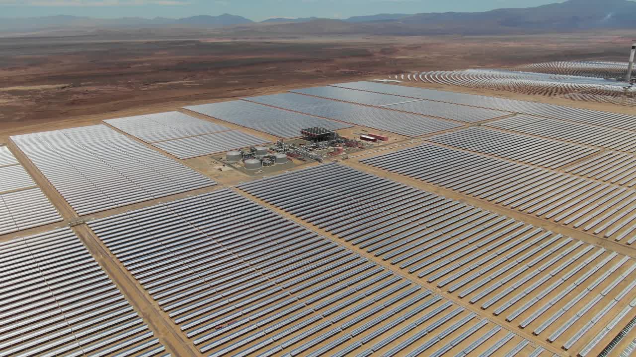 Luftfoto af Noor solcellekomplekset i Ouarzazate, Marokko, der viser store solspejlfelter og infrastruktur for vedvarende energi i ørkenlandskabet.