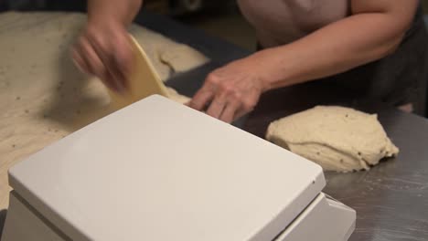 primer plano del peso de la masa antes de hornear el pan. panadería artesanal. trabajo profesional rápido de los panaderos