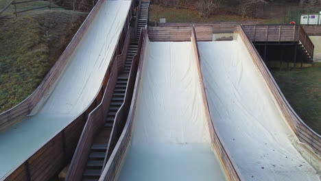 Low-aerial-dramatic-approaching-drone-shot-over-ski-jump-ramps-in-Slovenia