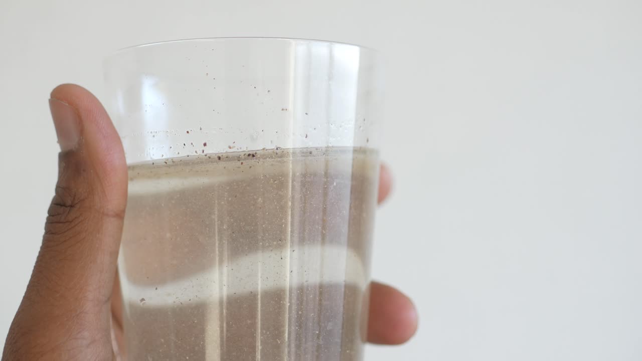 Sosteniendo un vaso de agua sucia