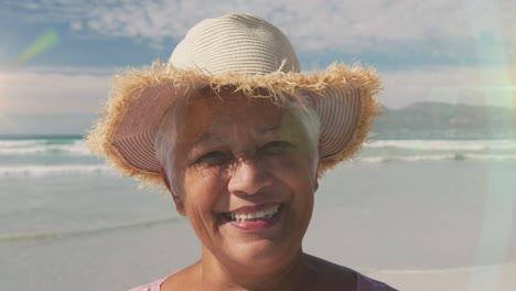 animation of glowing light over senior woman smiling by seaside