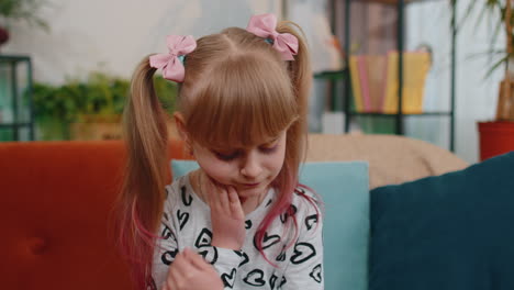 toddler kid girl touching cheek, terrible suffer from painful toothache, sensitive teeth, caries